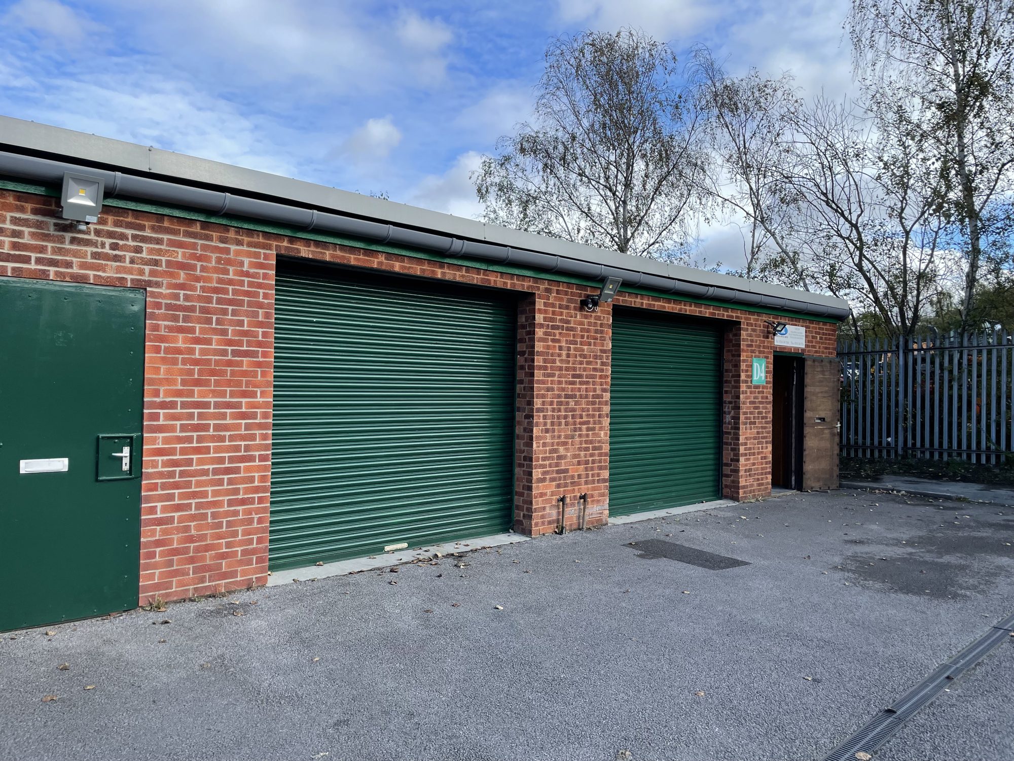 Brick units with green roller-shutter doors at Norwood Court
